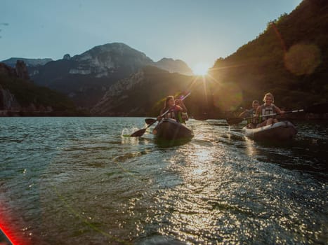 A group of friends enjoying fun and kayaking exploring the calm river, surrounding forest and large natural river canyons during an idyllic sunset