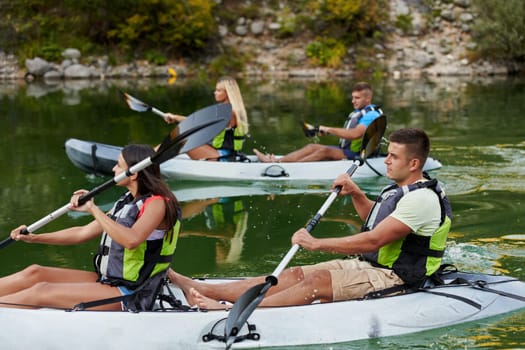 A group of friends enjoying having fun and kayaking while exploring the calm river, surrounding forest and large natural river canyons.