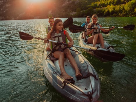 A group of friends enjoying fun and kayaking exploring the calm river, surrounding forest and large natural river canyons during an idyllic sunset