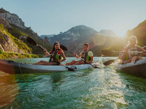 A group of friends enjoying fun and kayaking exploring the calm river, surrounding forest and large natural river canyons during an idyllic sunset