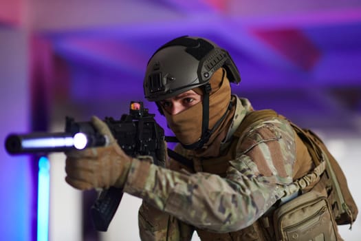 A professional soldier undertakes a perilous mission in an abandoned building illuminated by neon blue and purple lights.