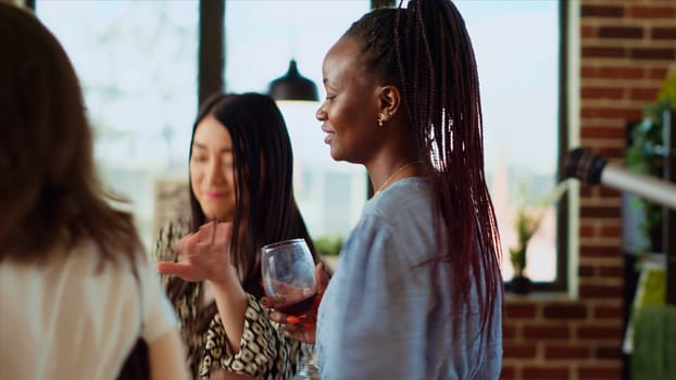 Close up shot of african american woman dancing around house during apartment party, Home guest enjoying lively music, doing dance moves and drinking wine at social gathering with her friends