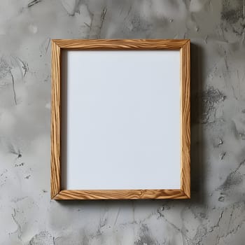 A rectangular brown wooden picture frame is hanging on a concrete wall, showcasing a beautiful piece of art. The frame is accented by a small twig and various tints and shades of paint