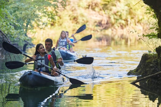 A group of friends enjoying having fun and kayaking while exploring the calm river, surrounding forest and large natural river canyons.