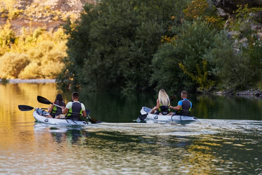 A group of friends enjoying having fun and kayaking while exploring the calm river, surrounding forest and large natural river canyons.