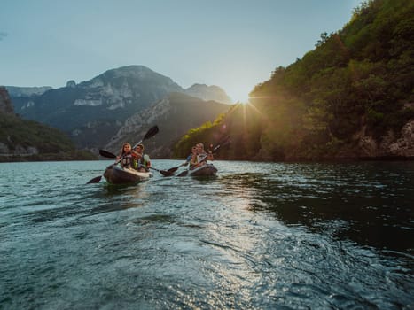 A group of friends enjoying fun and kayaking exploring the calm river, surrounding forest and large natural river canyons during an idyllic sunset