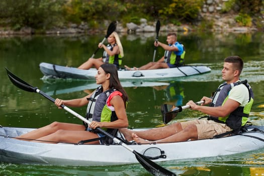 A group of friends enjoying having fun and kayaking while exploring the calm river, surrounding forest and large natural river canyons.