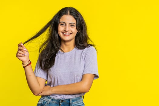 Cheerful lovely happy young Indian woman smiling friendly glad expression looking at camera dreaming resting relaxation feel satisfied good news. Arabian girl isolated on yellow studio background
