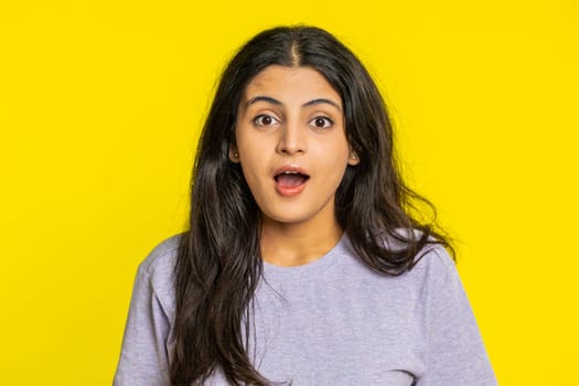 Oh my God, Wow. Excited amazed winner woman raising hands in surprise looking at camera with big eyes, shocked by sudden victory celebrating success achievement good news. Girl on yellow background