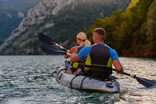 A group of friends enjoying having fun and kayaking while exploring the calm river, surrounding forest and large natural river canyons.