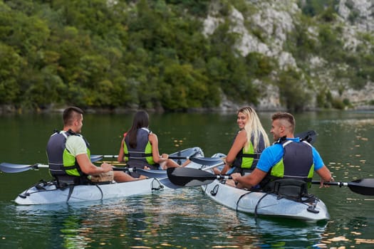 A group of friends enjoying having fun and kayaking while exploring the calm river, surrounding forest and large natural river canyons.