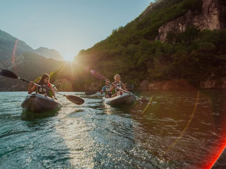 A group of friends enjoying fun and kayaking exploring the calm river, surrounding forest and large natural river canyons during an idyllic sunset