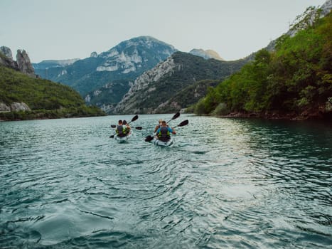 A group of friends enjoying fun and kayaking exploring the calm river, surrounding forest and large natural river canyons during an idyllic sunset