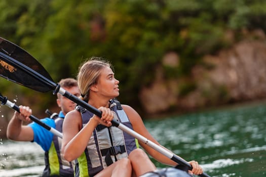 A young couple enjoying an idyllic kayak ride in the middle of a beautiful river surrounded by forest greenery.