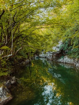 A group of friends enjoying having fun and kayaking while exploring the calm river, surrounding forest and large natural river canyons.