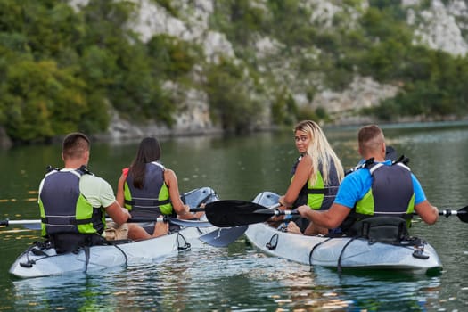 A group of friends enjoying having fun and kayaking while exploring the calm river, surrounding forest and large natural river canyons.