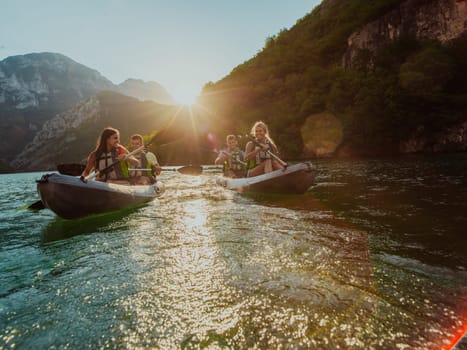 A group of friends enjoying fun and kayaking exploring the calm river, surrounding forest and large natural river canyons during an idyllic sunset