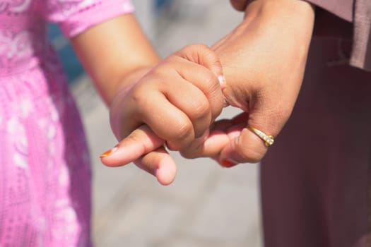 mother holding hand of little girl .