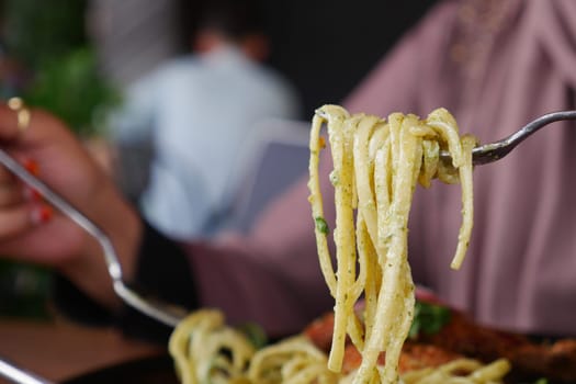 CloseUp of a Fork with Spaghetti in a Charming Italian Restaurant Setting.