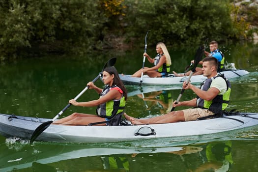 A group of friends enjoying having fun and kayaking while exploring the calm river, surrounding forest and large natural river canyons.