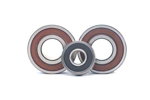 Deep groove ball bearings with rubber seals, each of different sizes, aligned vertically isolated on white background