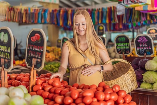 In a grocery store, a pregnant woman stands by a fruit stand, surrounded by various natural foods. She is in a public space where the local market offers whole foods for trade Pregnant woman buying organic vegetables and fruits at Mexican style farmers market