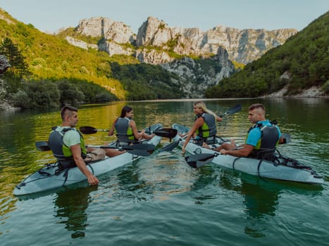 A group of friends enjoying having fun and kayaking while exploring the calm river, surrounding forest and large natural river canyons.