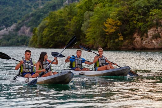 A group of friends enjoying having fun and kayaking while exploring the calm river, surrounding forest and large natural river canyons.