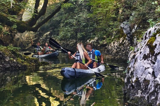 A group of friends enjoying having fun and kayaking while exploring the calm river, surrounding forest and large natural river canyons.