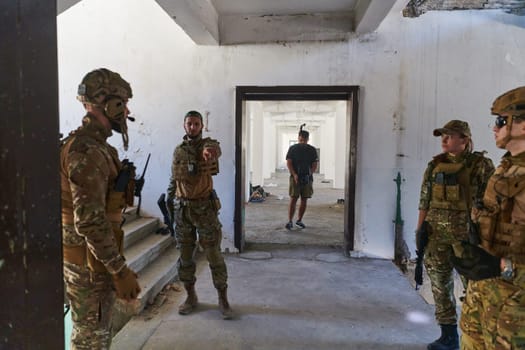 Group of soldiers discusses military tactics while situated in an abandoned building, meticulously planning their moves with focus and determination