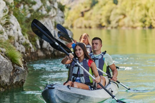 A group of friends enjoying having fun and kayaking while exploring the calm river, surrounding forest and large natural river canyons.