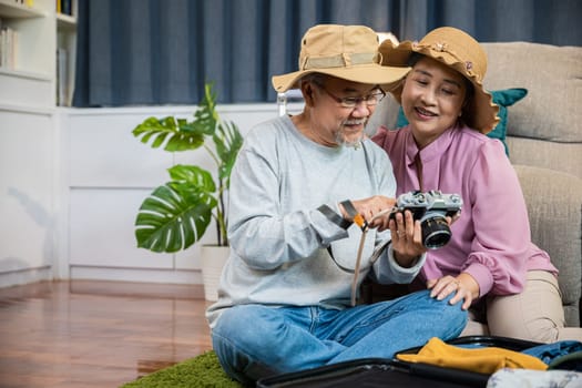 Travel and tourism. Asian couple old senior marry retired couple smiling taking photo by camera during luggage suitcase arranging for travel, Happy mature retired couple photography weekend holiday