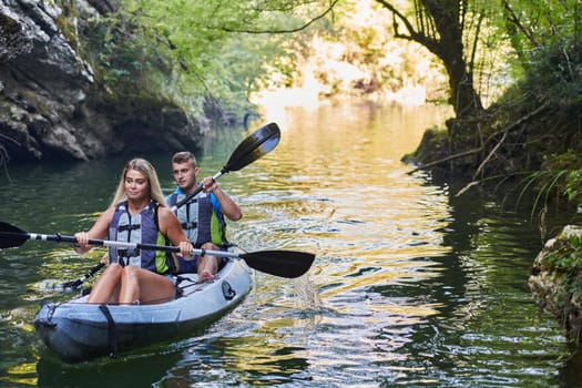 A group of friends enjoying having fun and kayaking while exploring the calm river, surrounding forest and large natural river canyons.