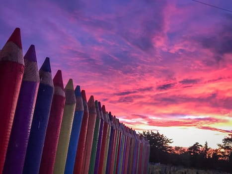 A beautiful image of a school wall in coloured pencils against a blushing evening sky, High quality photo