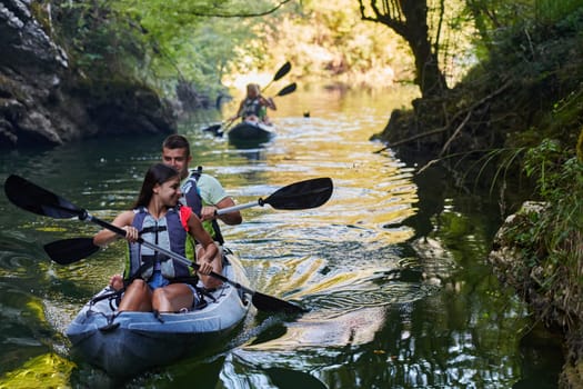 A group of friends enjoying having fun and kayaking while exploring the calm river, surrounding forest and large natural river canyons.