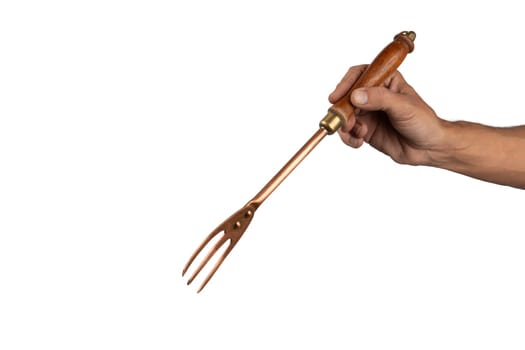 Black male hand holding a vintage brass meat fork on white background. High quality photo