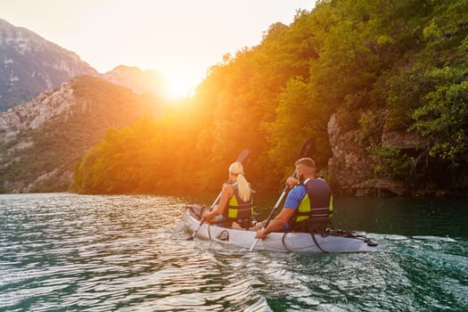 A group of friends enjoying fun and kayaking exploring the calm river, surrounding forest and large natural river canyons during an idyllic sunset