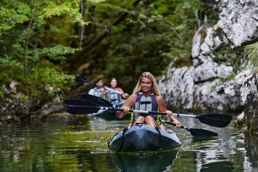 A group of friends enjoying having fun and kayaking while exploring the calm river, surrounding forest and large natural river canyons.