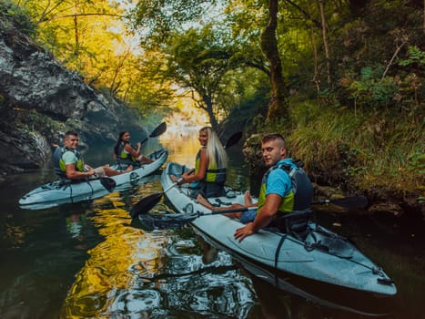 A group of friends enjoying having fun and kayaking while exploring the calm river, surrounding forest and large natural river canyons.