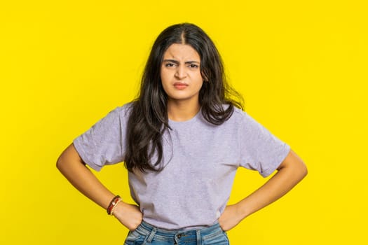 Irritated angry Indian woman screams from stress tension problems feels horror hopelessness fear surprise shock expresses rage nervous, quarrel. Arabian young girl isolated on yellow studio background