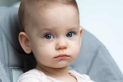 Close-up of an infant baby gazing at the camera with wide-eyed wonder