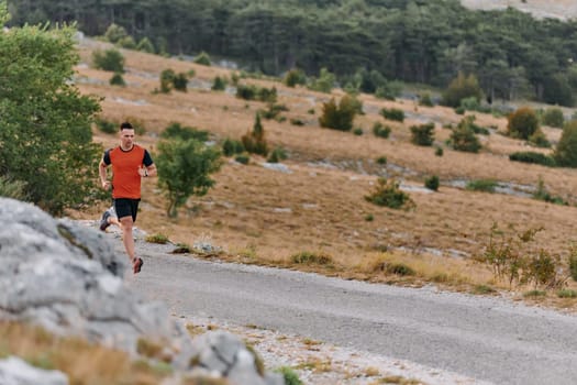 A muscular male athlete runs along a rugged mountain path at sunrise, surrounded by breathtaking rocky landscapes and natural beauty.