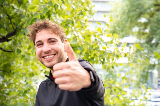 Happy man looking at camera pointing finger up Man resting during his morning workout.