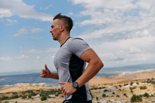 A muscular male athlete runs along a rugged mountain path at sunrise, surrounded by breathtaking rocky landscapes and natural beauty.