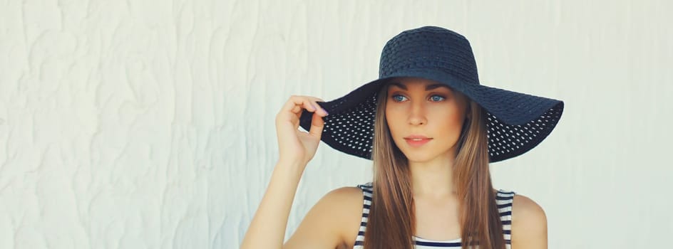 Portrait of beautiful blonde young woman in summer straw hat looking away on white background