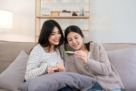 Two young women looking at pregnancy test result together at home. Concept of friendship and shared moments.