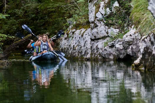 A young couple enjoying an idyllic kayak ride in the middle of a beautiful river surrounded by forest greenery.