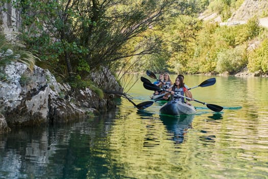 A group of friends enjoying having fun and kayaking while exploring the calm river, surrounding forest and large natural river canyons.