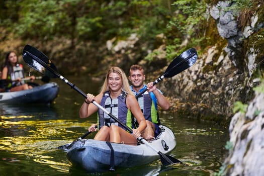 A group of friends enjoying having fun and kayaking while exploring the calm river, surrounding forest and large natural river canyons.