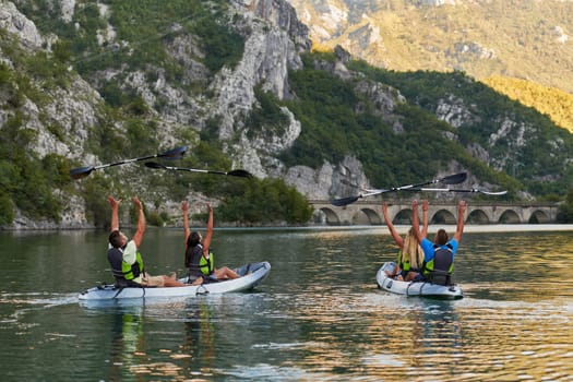 A group of friends enjoying having fun and kayaking while exploring the calm river, surrounding forest and large natural river canyons.